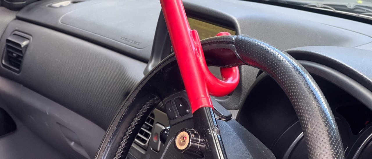 car steering wheel lock A red bar car steering wheel lock on a steering wheel