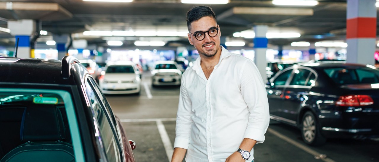 man unlocking car in car park