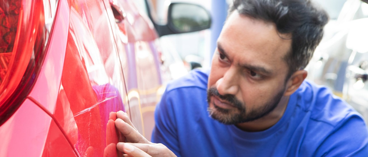 Car-scratch-inspect-Getty-1663534342.jpg Man inspects scratches on red car