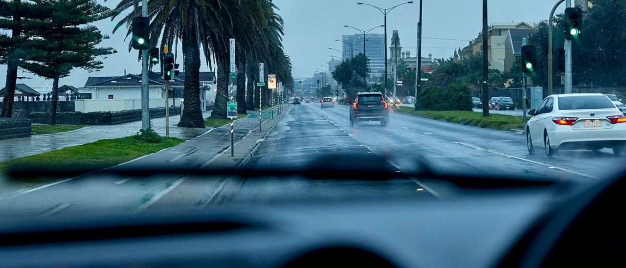 Driver's view of sparse traffic on wet Melbourne road.