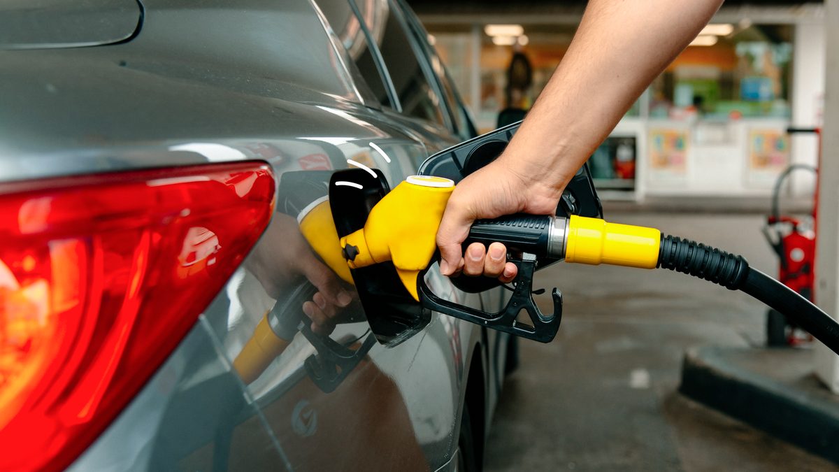 A close-up of a person filling up their car with fuel at a service station
