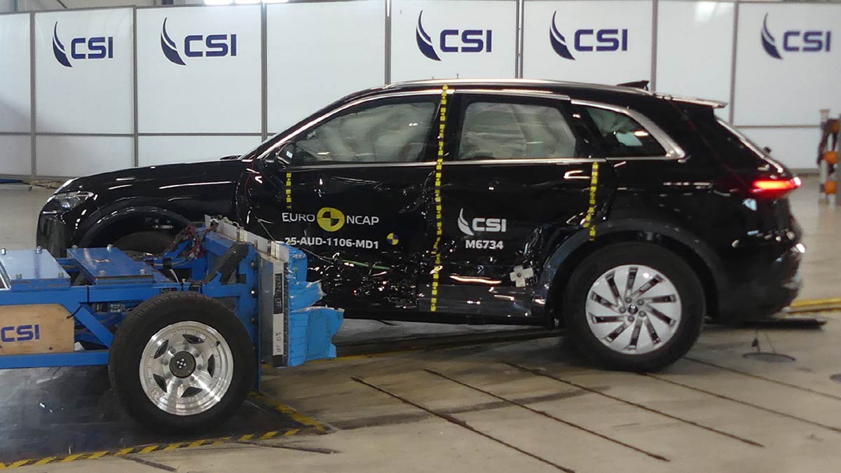 Black Audi Q5 SUV with damaged side panels after collision with barrier in Euro NCAP side impact test. 