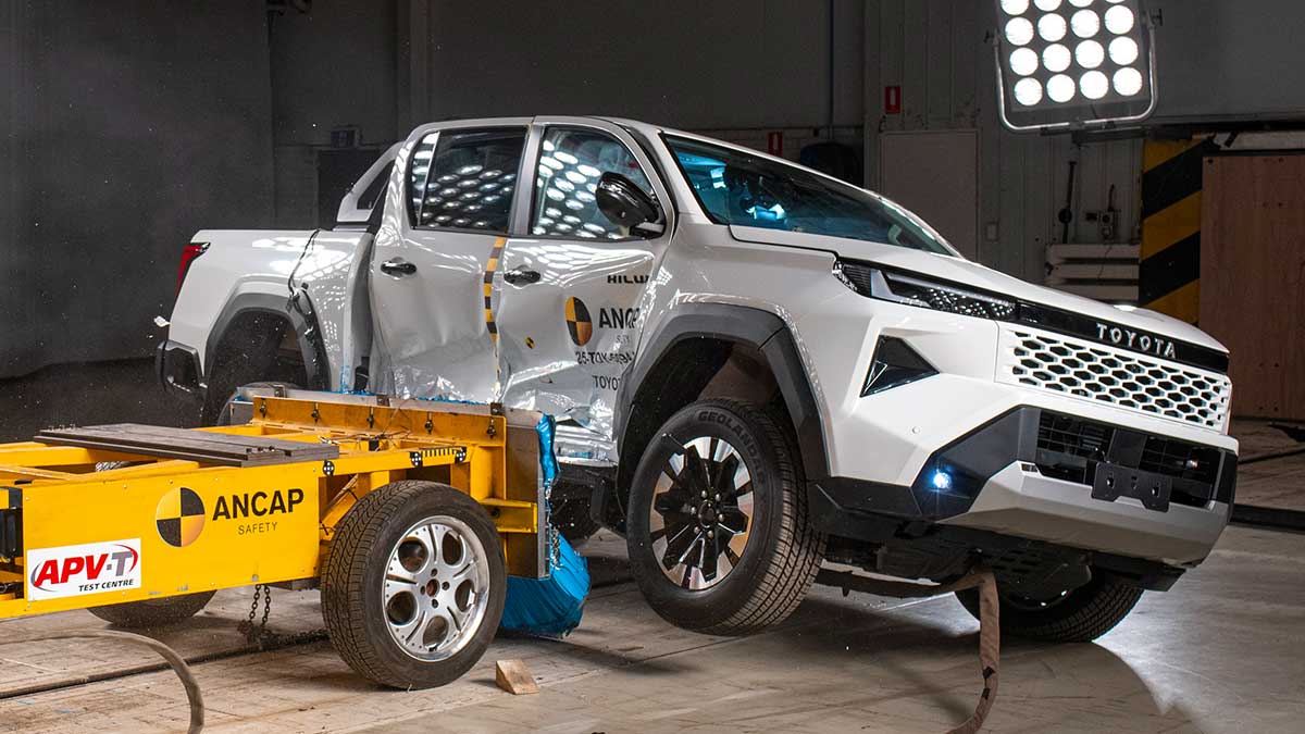 White Toyota HiLux ute being hit side-on by moveable deformable barrier in ANCAP crash test.