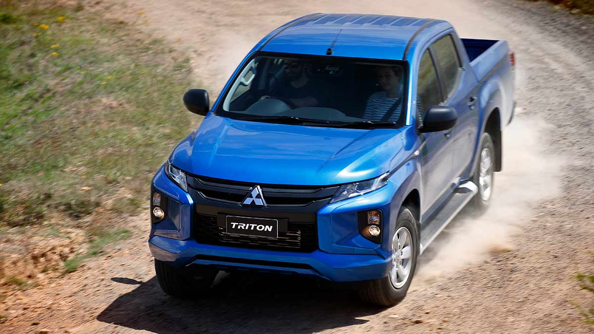 A blue Mitsubishi Triton on a gravel road.