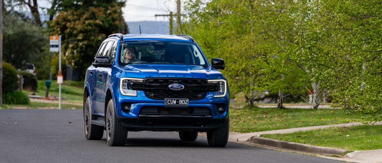 Woman driving Ford Everest along suburban road