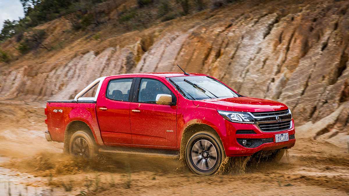 Red Holden SUV driving through mud
