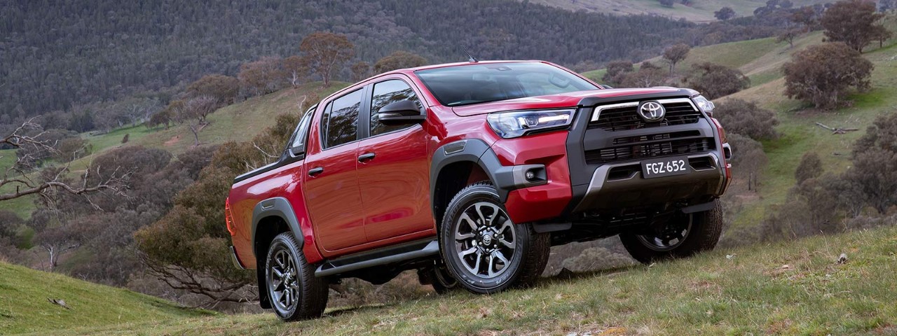 A red Toyota Hilux on a hill