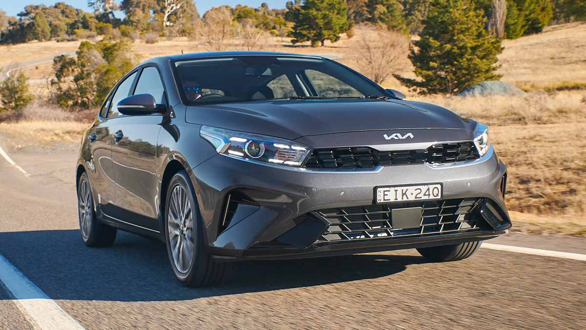 Grey Kia Cerato driving on country road