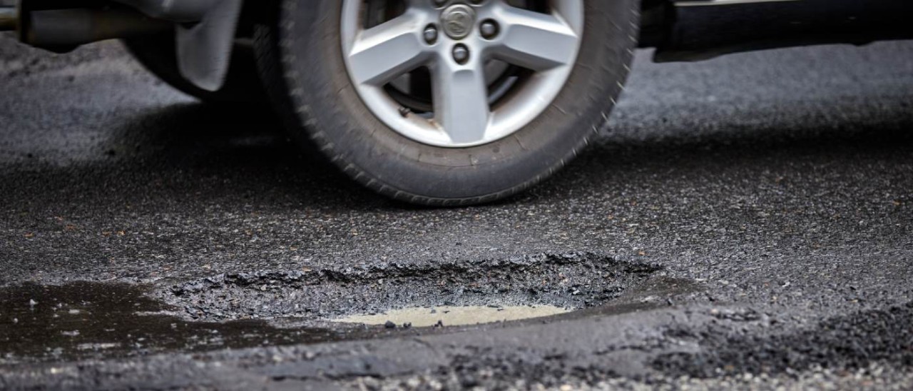 car tyre near pothole in road