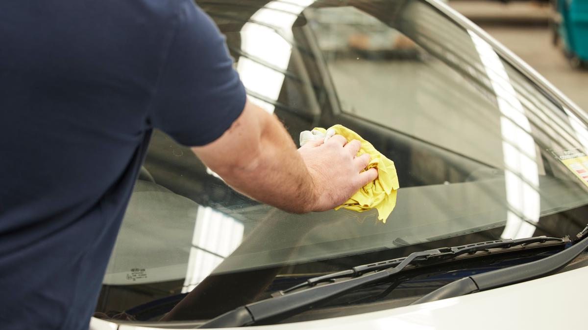 man cleaning windscreen