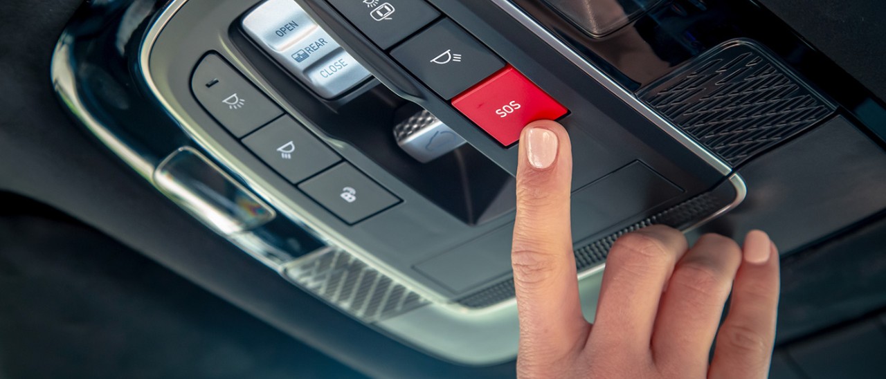 Finger on red SOS button in overhead console of Hyundai Palisade SUV