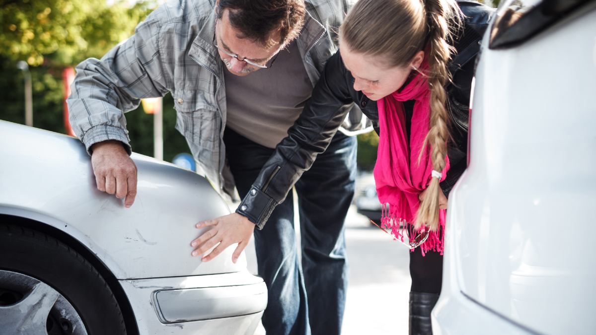 man and woman examining scratches on a car