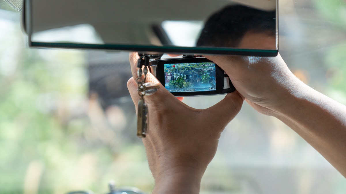 man installing dashcam in car