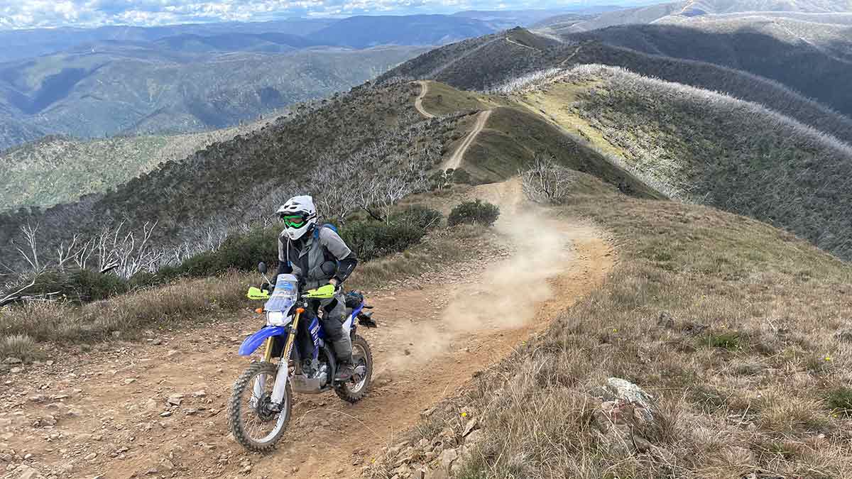 Trail bike rider on track at top of mountain range in Victorian high country
