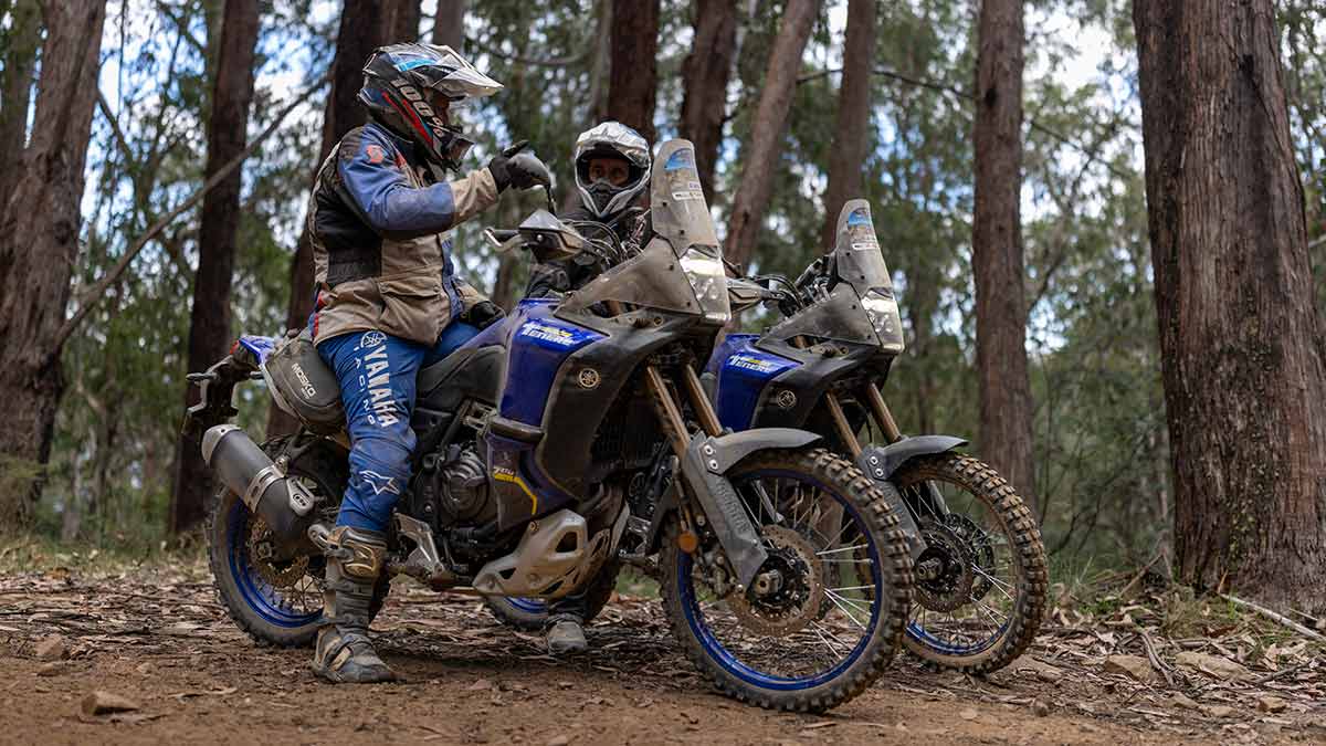 Two trail bike riders talking at rest stop on track in Victorian high country