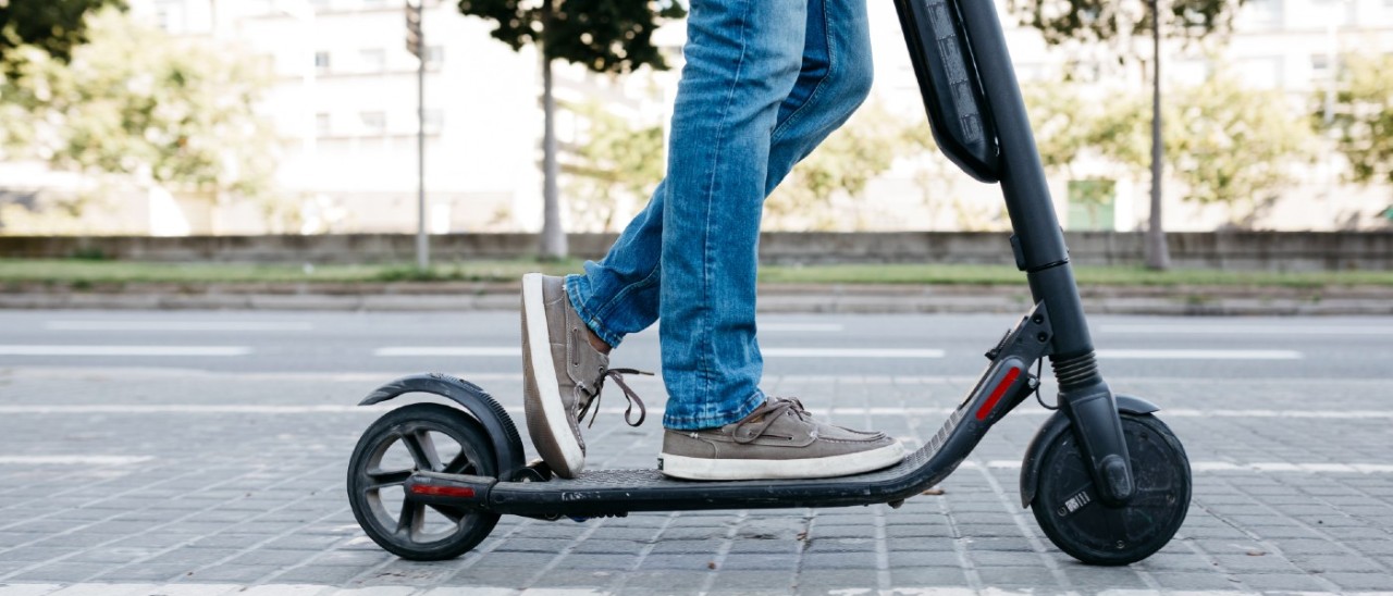 young man riding an e-scooter outside