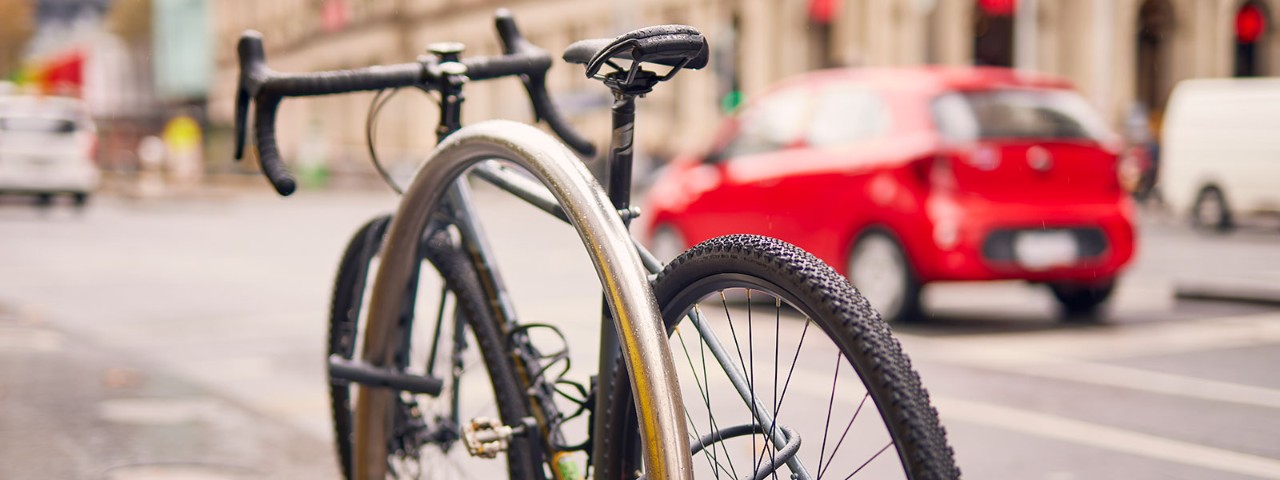 Bicycle locked to bike rack next to main road