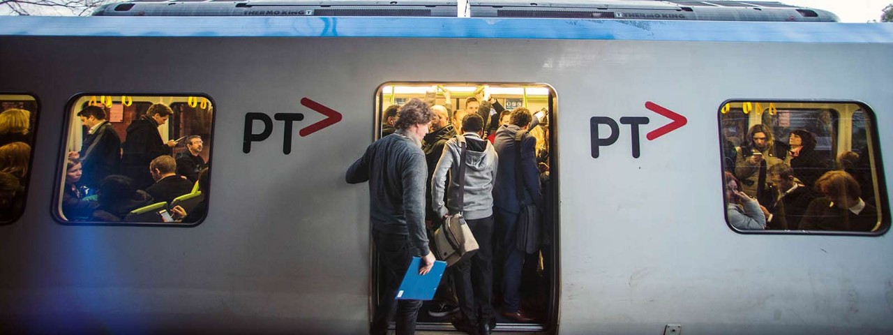 Packed train with people trying to get in before the door closes.