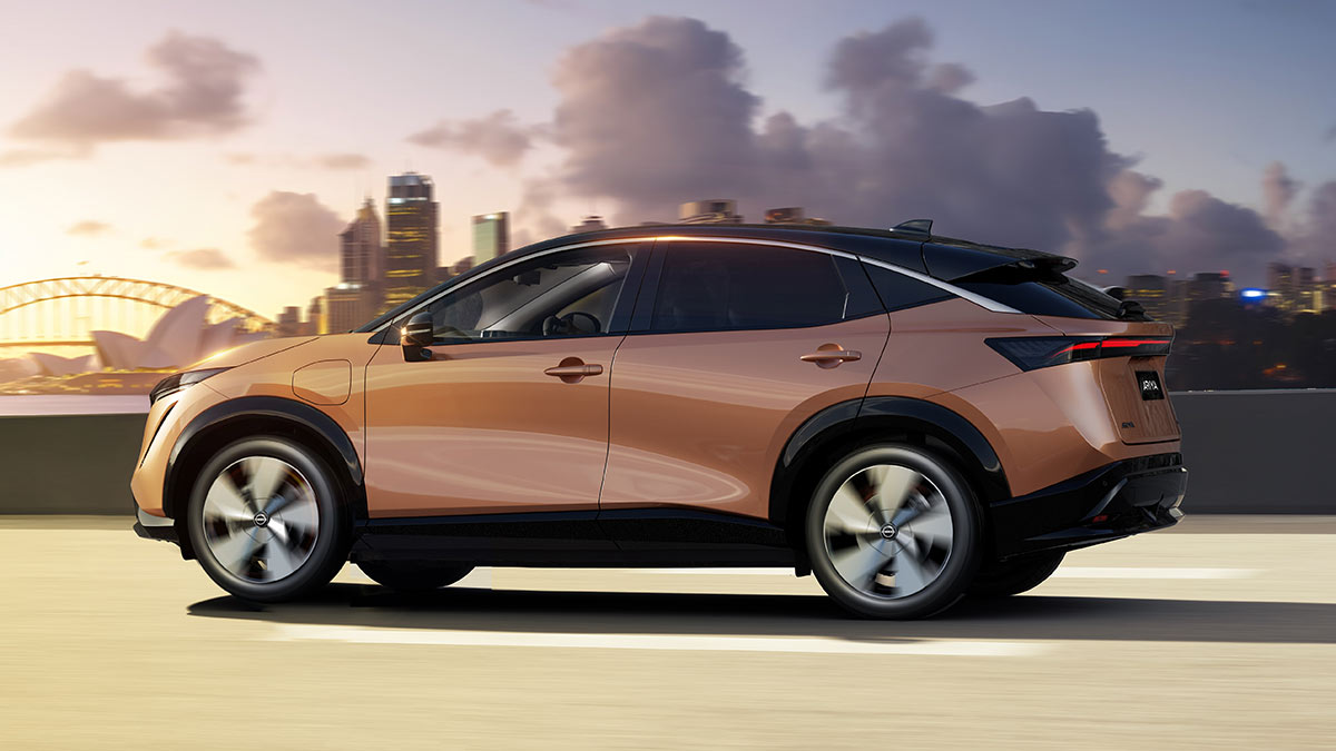 Side view of copper-coloured Nissan Ariya medium electric SUV with Sydney Opera House and Harbour Bridge in background
