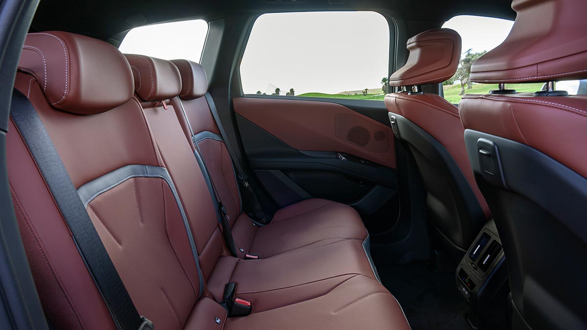 Rear seat area of BMW iX3 electric SUV with earthy brown Castanea seat upholstery.