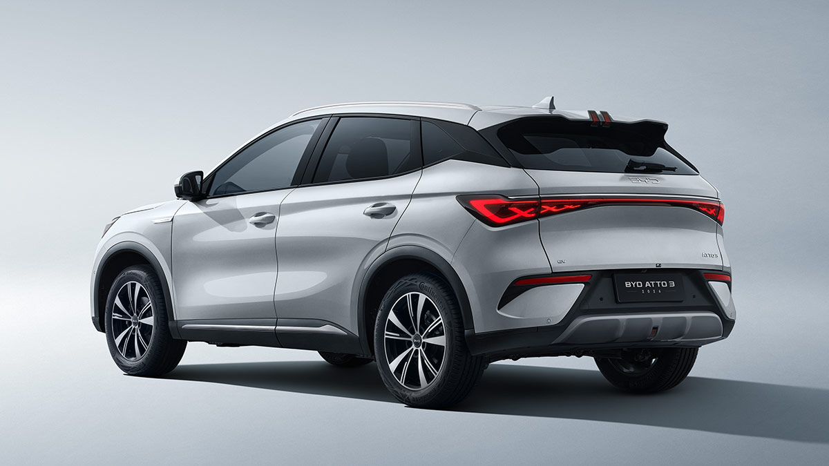 Rear quarter view of BYD Atto 3 Dynamic electric SUV with flared high-mount roof spoiler and full-width LED light bar.