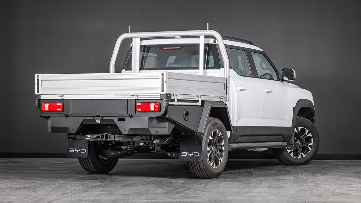 Studio shot showing rear three-quarter angle of white BYD Shark 6 Cab-Chassis dual-cab ute fitted with optional alloy tray.