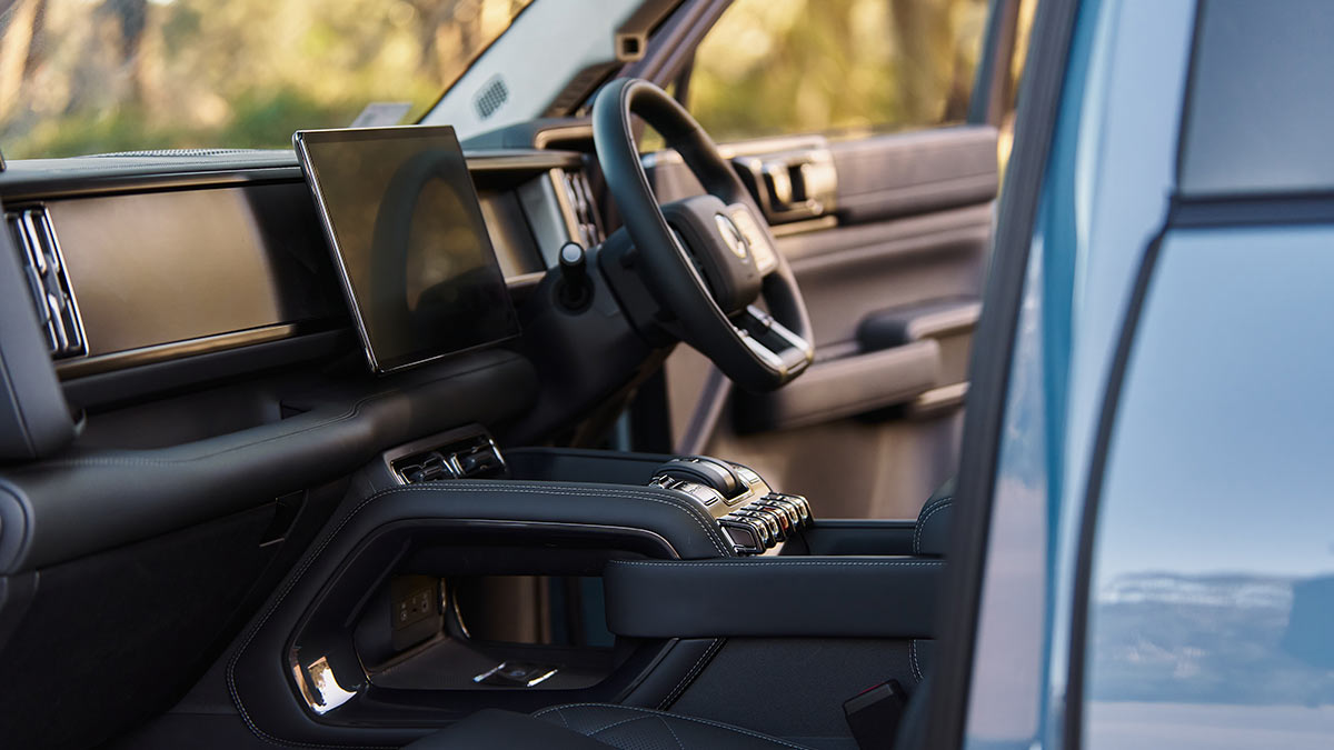 Denza B5 luxury SUV's front seat area with large digital screens and raised console, as seen from front passenger door.