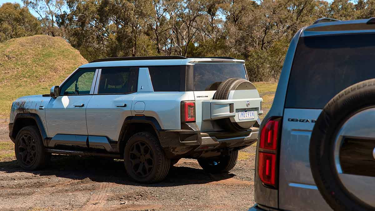 Partial view of Denza B5 tailgate with Denza B8 SUV ahead on off-road course at Lang Lang proving ground.