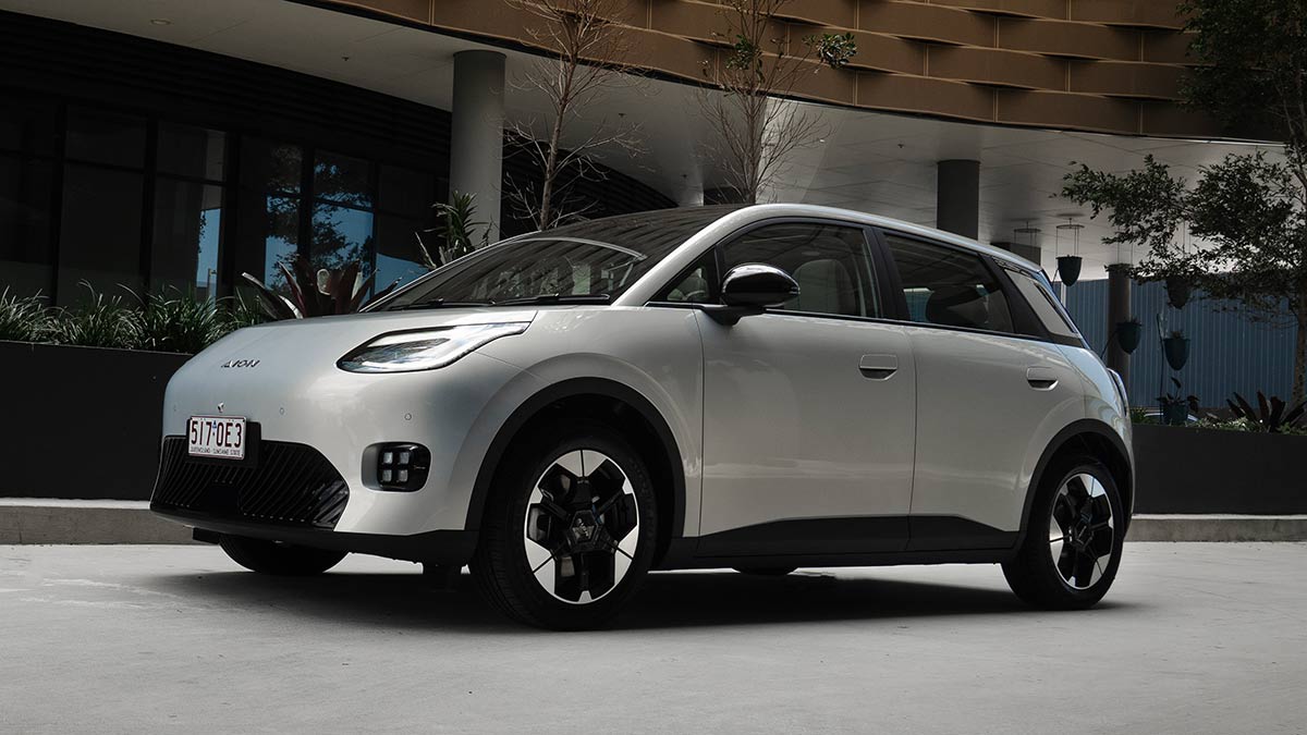 Silver GAC Aion UT electric hatch parked in front of luxury apartment building in Brisbane.