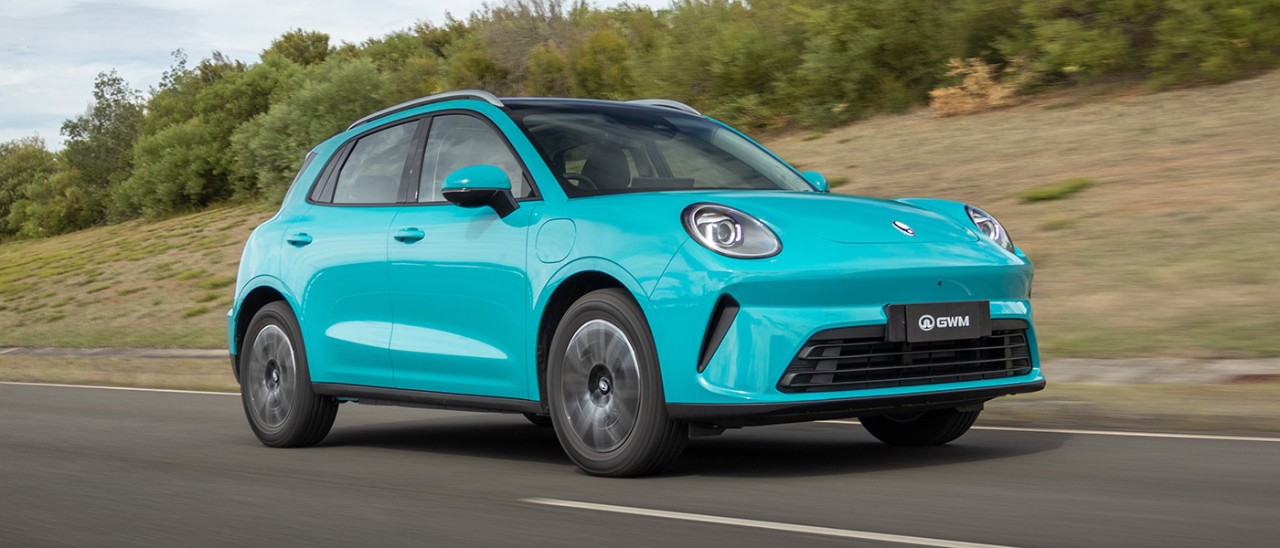Duck-egg blue GWM Ora 5 electric small SUV driving on ride and handling circuit at Lang Lang proving ground in Victoria.