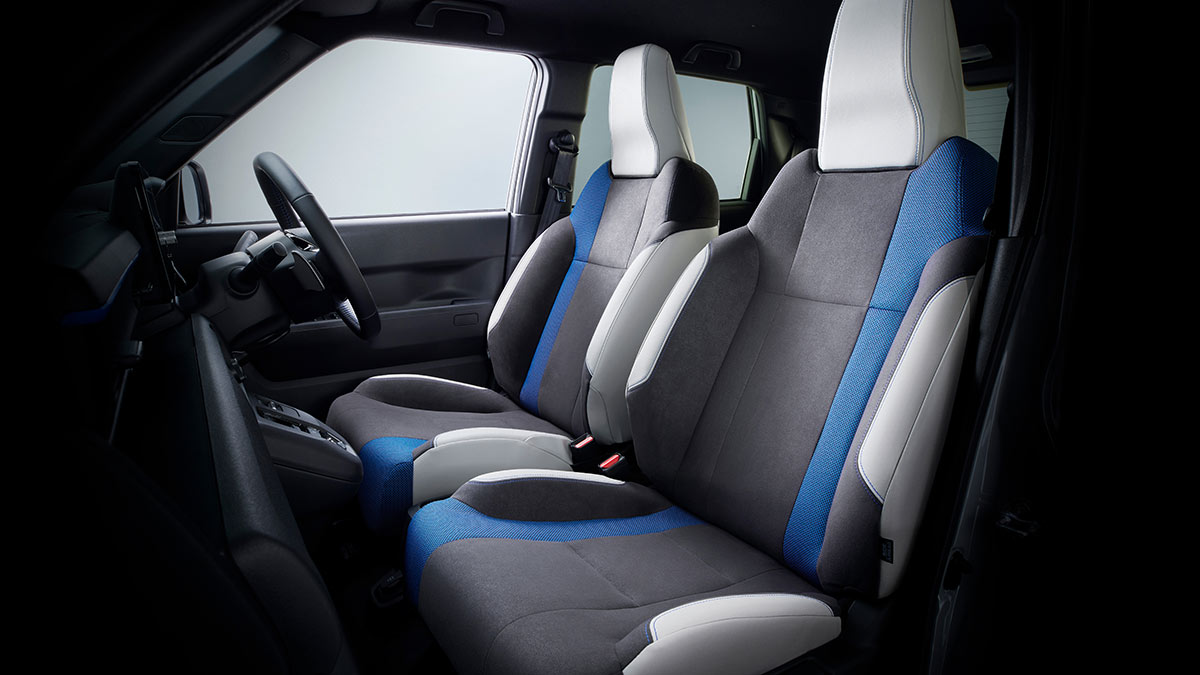 Honda Super-One EV’s heavily bolstered front sports seats with grey and white fabric trim and thick blue stripes. 