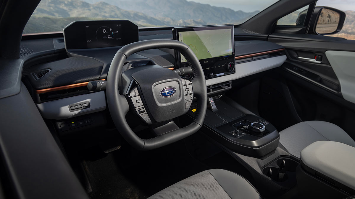 Cockpit of left-hand-drive US-spec Subaru Uncharted small electric SUV with twin digital screens and oval-shaped steering wheel.