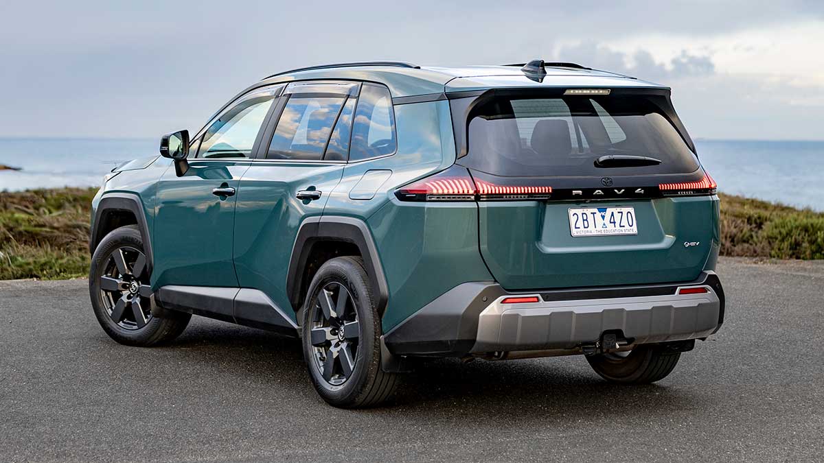 Rear view of metallic green Toyota RAV4 Edge SUV at beachside carpark overlooking ocean.
