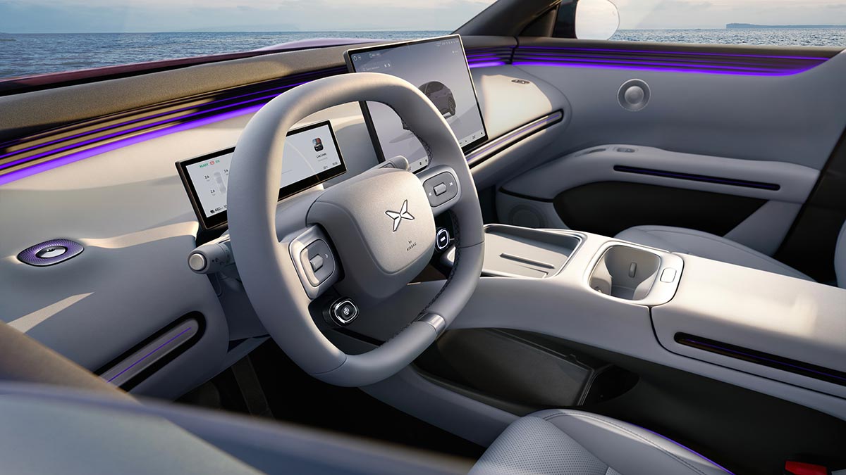 XPeng L03 dash from driver’s door in left-hand-drive overseas model with dual screens and bridge-style console.