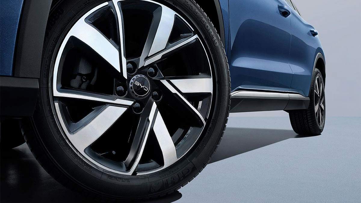 Close-up of alloy wheel at front of BYD Sealion 5 medium SUV in studio.