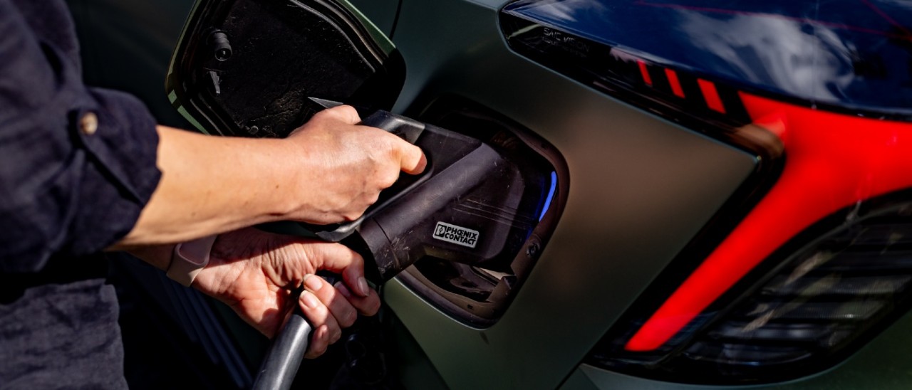 A person plugging a charger into a green MG4 Xpower