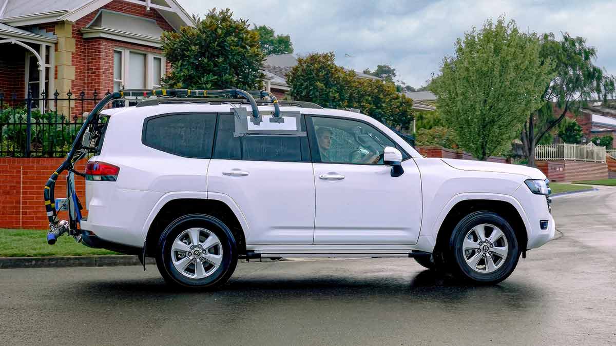 Suburban street scene with white Toyota LandCruiser rigged up for real-world economy and emissions testing.