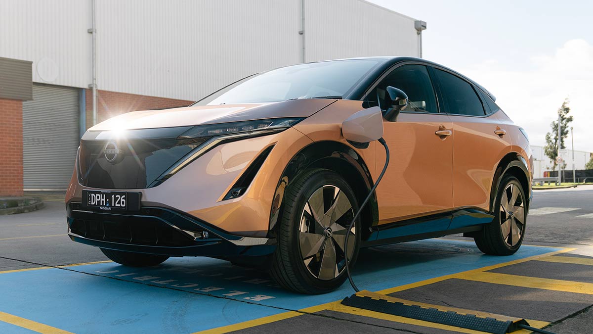 Gold Nissan Ariya Evolve electric SUV at charging station at company's Melbourne headquarters.