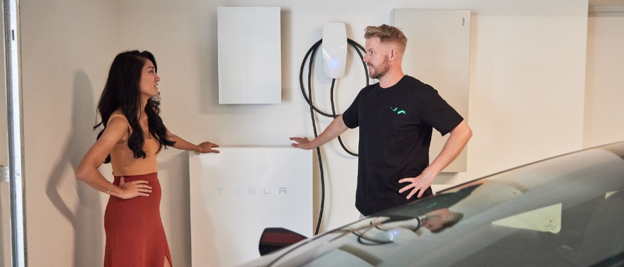 woman and man talking in front of a home EV charger