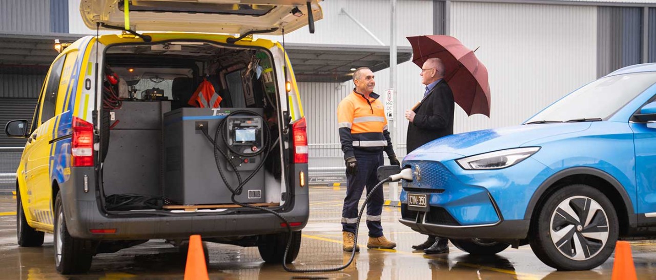 RACV ERA van charging an EV as a patrolman assists the driver