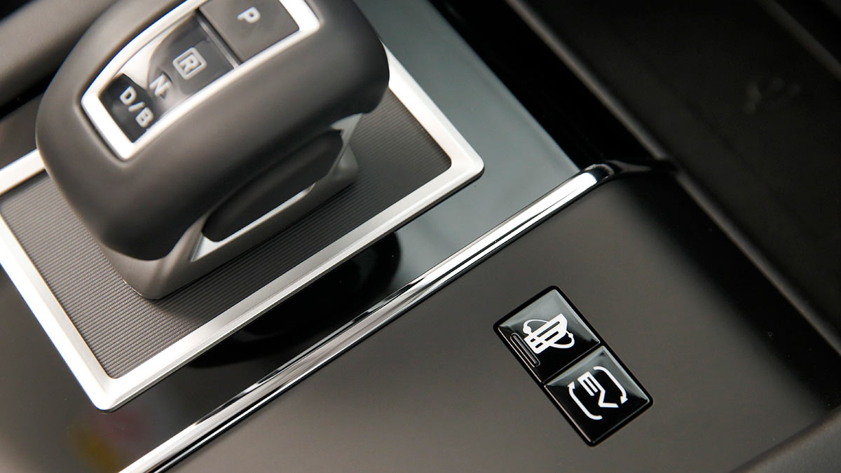 Centre console of Mitsubishi Outlander PHEV showing EV mode and one-pedal driving mode buttons.