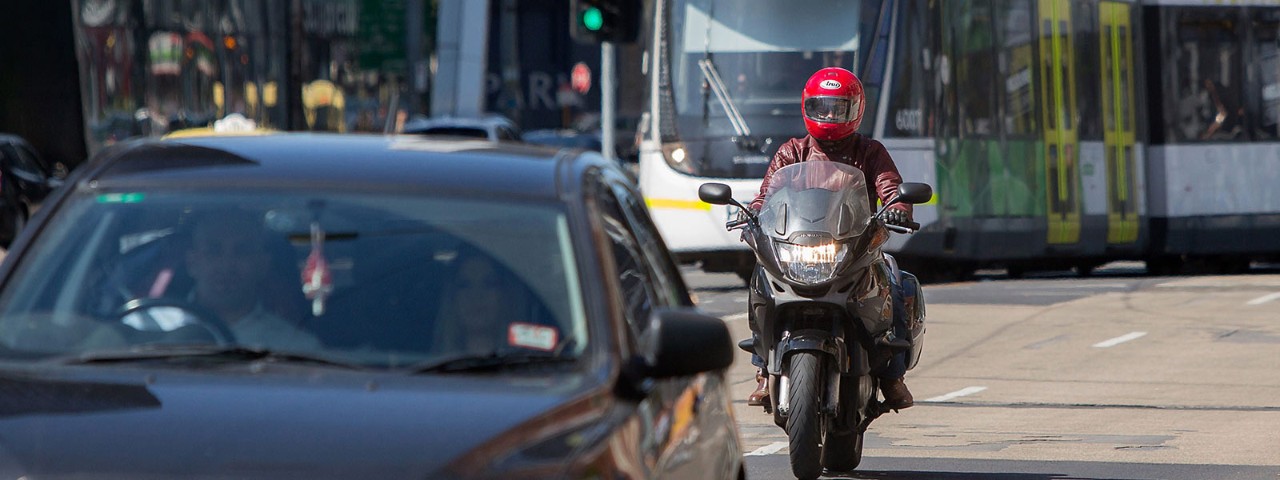 Man riding motorcycle through traffic