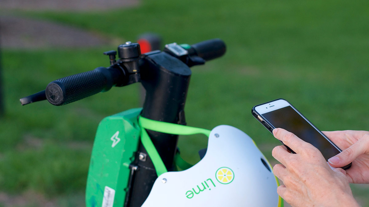 Person using a mobile phone app to unlock an electric scooter