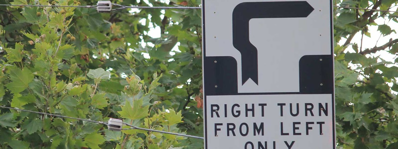 Hook turn road sign with tree in background.