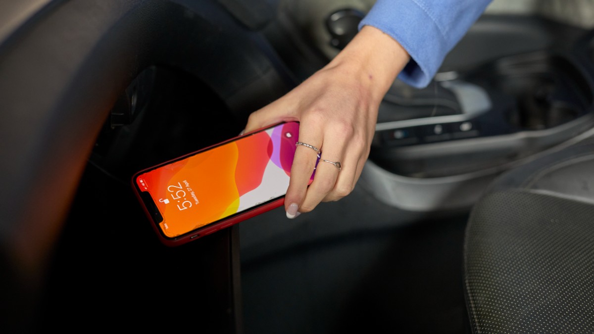 Person using mobile phone inside car while parked