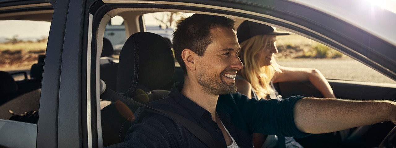 936029700 man and woman driving a car