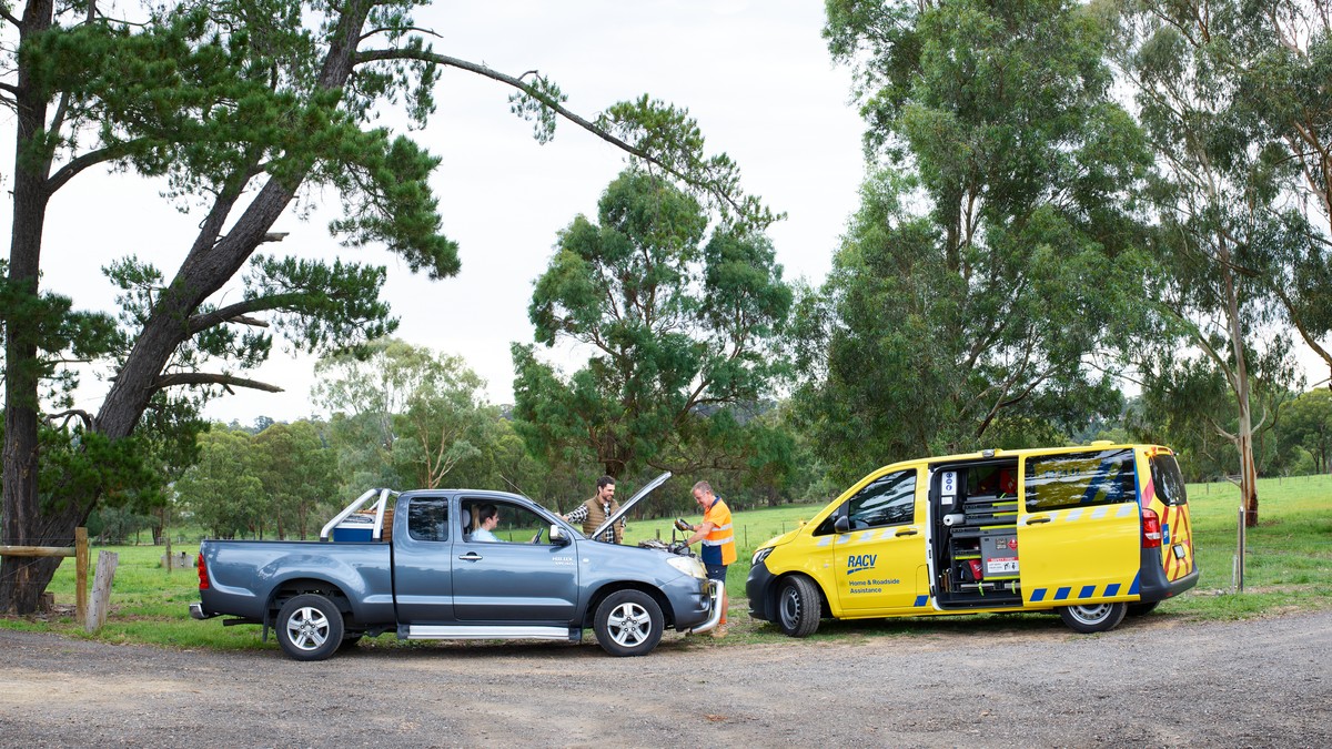 A ute on a country road receives assistance from an RACV Emergency Roadside Assistance technician