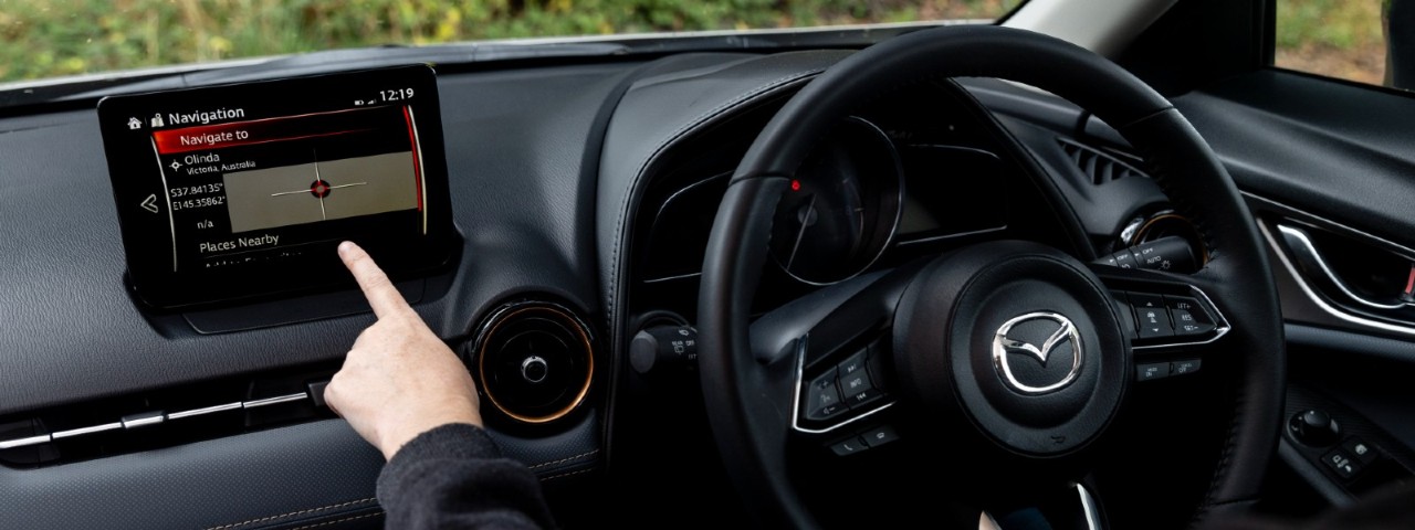 person using navigation interface on infotainment screen in Mazda CX-3 Touring SP