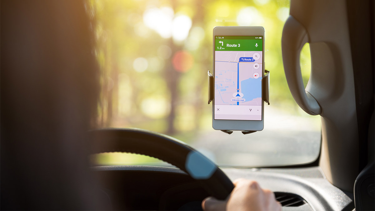 A mobile phone with a GPS tool on it mounted to a car windscreen