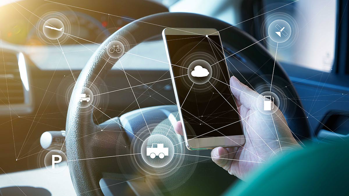 A mobile phone being looked at from behind the driver's wheel